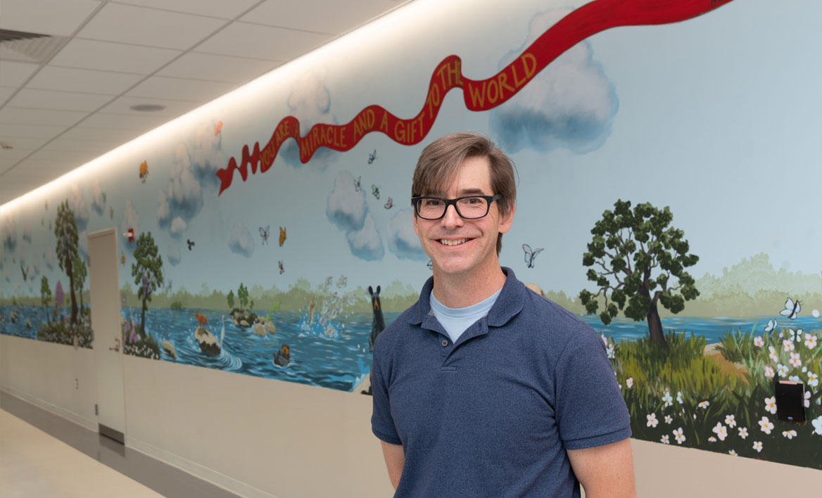 photo of alumnus Matt Lively and the mural he painted at the VTCC