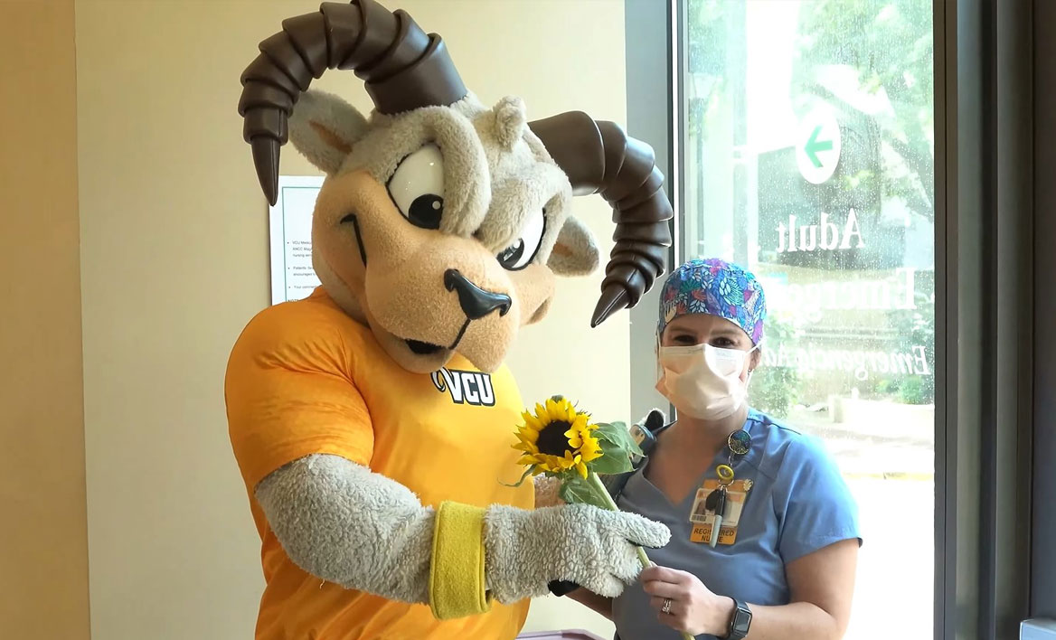 Rodney giving a sunflower to a VCU Health team member