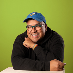 A person in a black sweatshirt with a green background